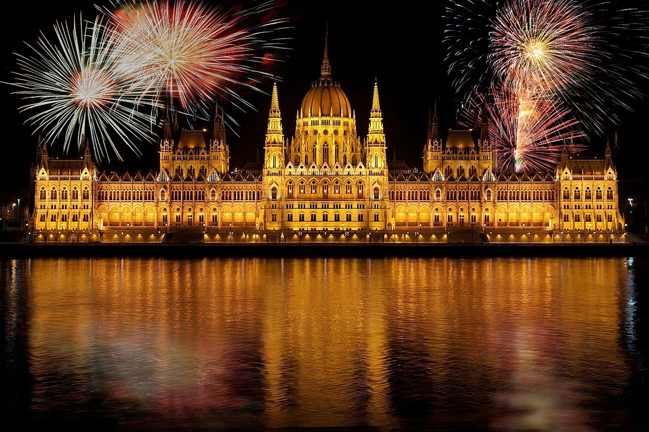 Parlament w Budapeszcie nocą ze sztucznymi ogniami rozświetlającymi niebo