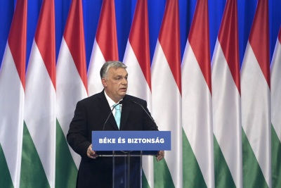 Premier Węgier przemawia na tle flag