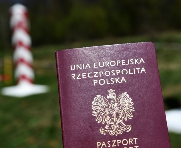 Paszport Polski na tle słupa granicznego