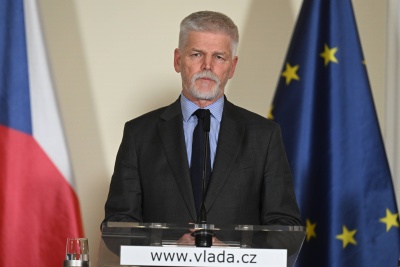 Prezydent Czech Petr Pavel przemawia na tle flag