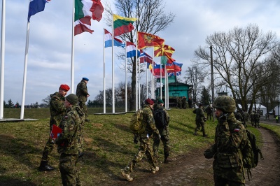 Soldiers walk past NATO members country flags during the DRAGON-24 NATO military defense drills in Korzeniewo, Poland