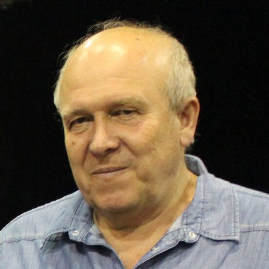 Portret Lajosa Pálfalviego na czarnym tle. Tłumacz ubrany jest w niebieską koszulę i lekko się uśmiecha.